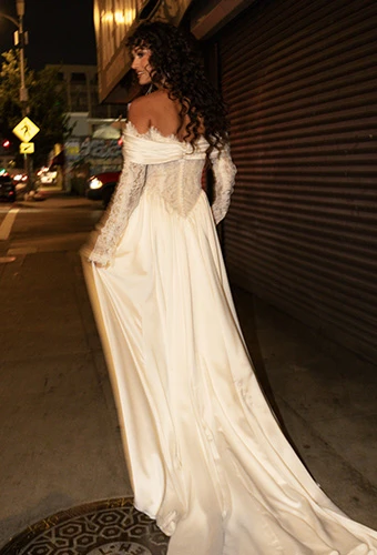 Bride wearing wedding gown with lace bodice and lace off the shoulder sleeves and high leg slit