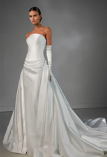 Bride wearing strapless sleek column wedding dress with internal corset and detachable overskirt
