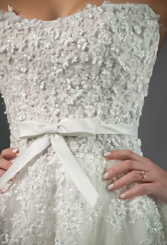 Bride wearing strapless wedding dress with sparkling beads and bow belt detail