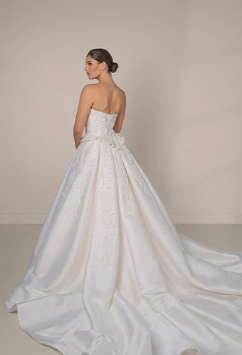 Bride wearing strapless ballgown wedding dress with straight across neckline and waist detail