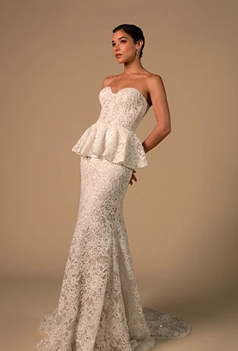 Bride wearing lace strapless mermaid wedding dress with peplum waist