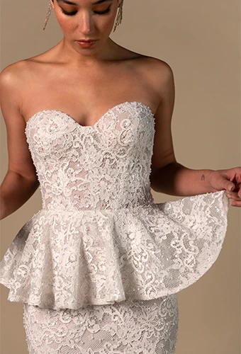 Bride wearing lace strapless mermaid wedding dress with peplum waist