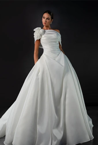 Bride wearing a-line wedding dress with asymmetrical one shoulder and floral accent