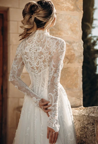 Bride wearing sparkline lace wedding dress with high neckline and long sleeves