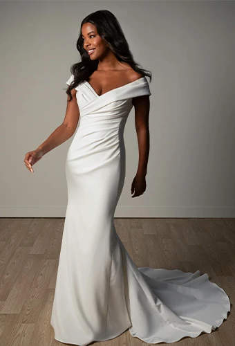 Bride wearing simple wedding dress with draping and off-the-shoulder straps