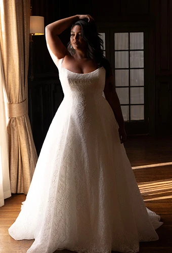 Plus size bride wearing strapless ballgown wedding dress with scoop neckline and allover lace