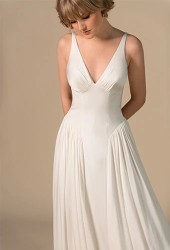 Bride wearing simple a-line wedding dress with drop waist and shoulder straps