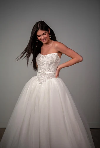 Bride wearing strapless ballgown wedding dress with lace bodice and bow belt detail