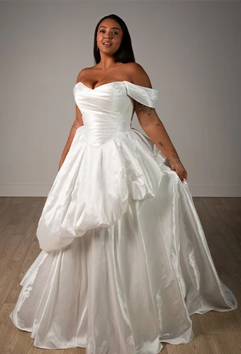 Plus size bride wearing off-the-shoulder ballgown wedding dress with sweetheart neckline and basque waist