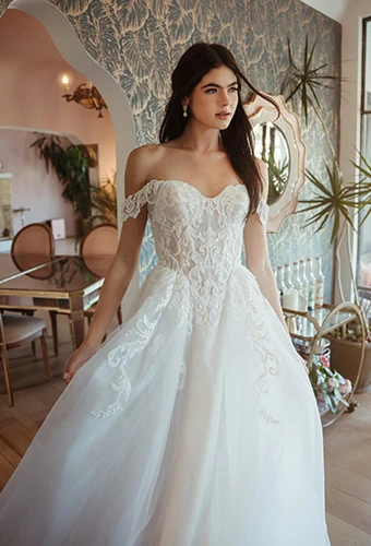 Bride wearing lace wedding gown with off-the-shoulder straps and sweetheart neckline