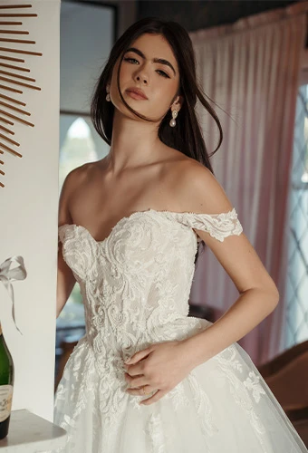 Bride wearing lace and beaded wedding gown with off-the-shoulder straps and sweetheart neckline