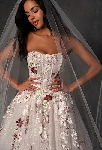 Close up of bride wearing strapless glitter tulle a-line wedding dress with sculpted waistline and floral motifs