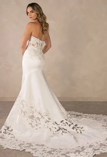 Bride in a classic ivory mermaid wedding dress with a sweetheart neckline and show-stopping lace train