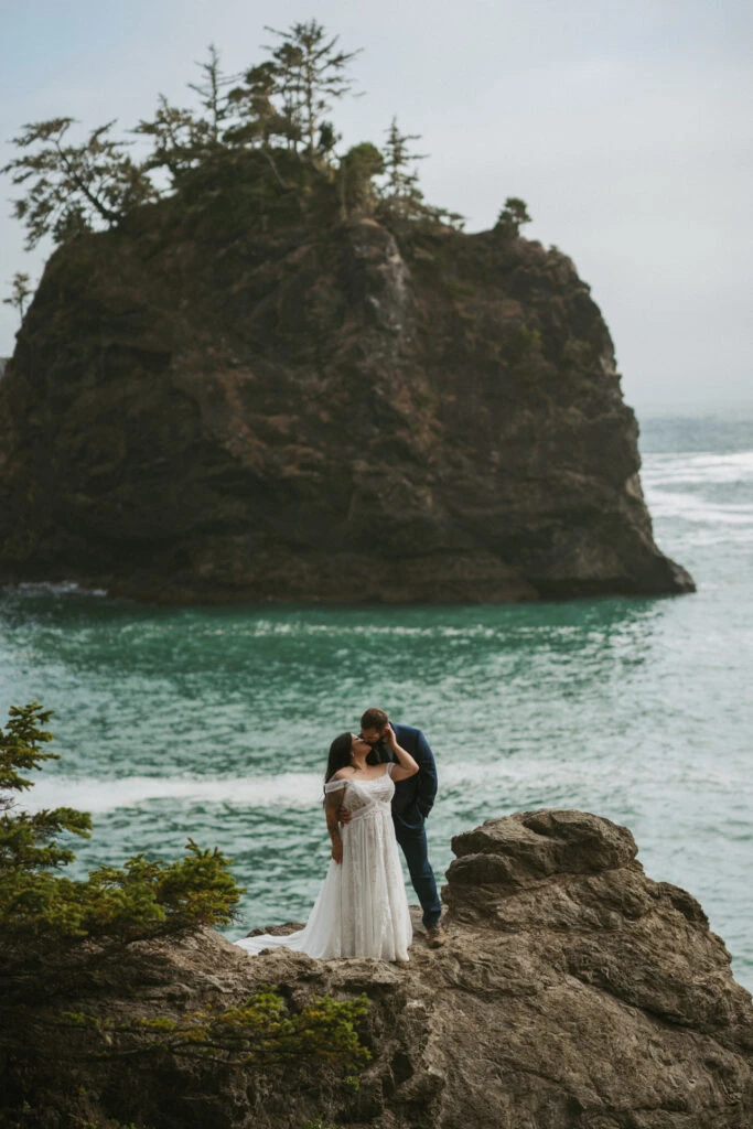 True Bride Teresa and Eric embrace on a coastal cliff overlooking the ocean.