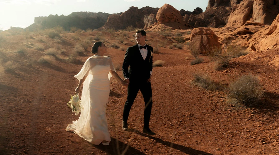 Real bride Erica and groom Trey walk through the red rock desert at Valley of Fire State Park.