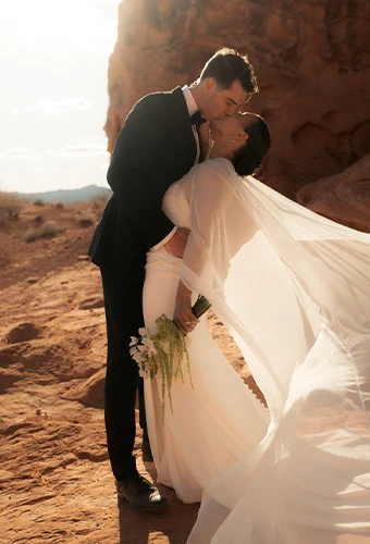 Real bride Erica and groom Trey sharing a romantic kiss in the desert.