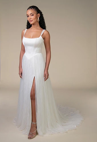 Same white wedding dress shown without the detachable sleeves, featuring a fitted square-neckline bodice and flowing skirt with a high slit, photographed against a neutral background