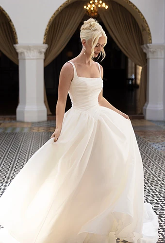 Bride wearing ballgown wedding dress with square neckline and straps