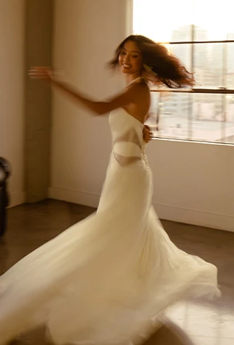 Bride wearing strapless a line wedding dress with side cutouts, twirling