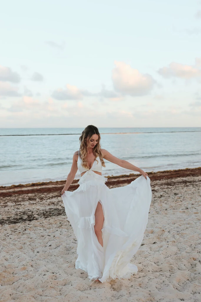 Real bride Mercedez posing in her wedding gown on the beach