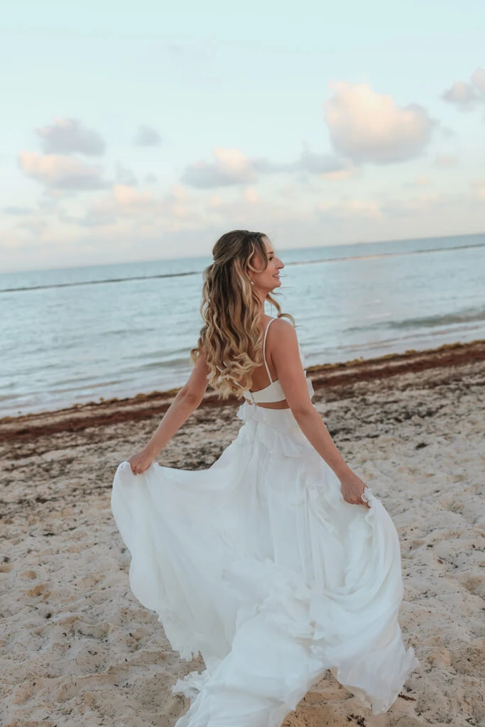 Real bride Mercedez posing in her wedding gown on the beach
