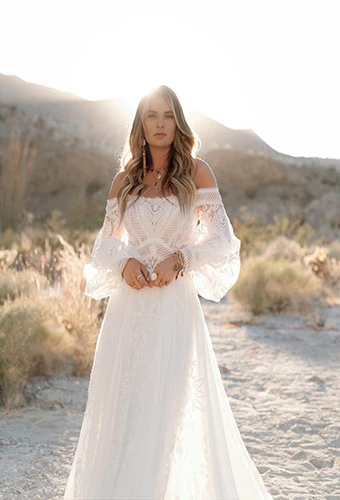Bride wearing off-the-shoulder matte lace and crepe chiffon boho gown with blouson sleeves, All Who Wander maddox