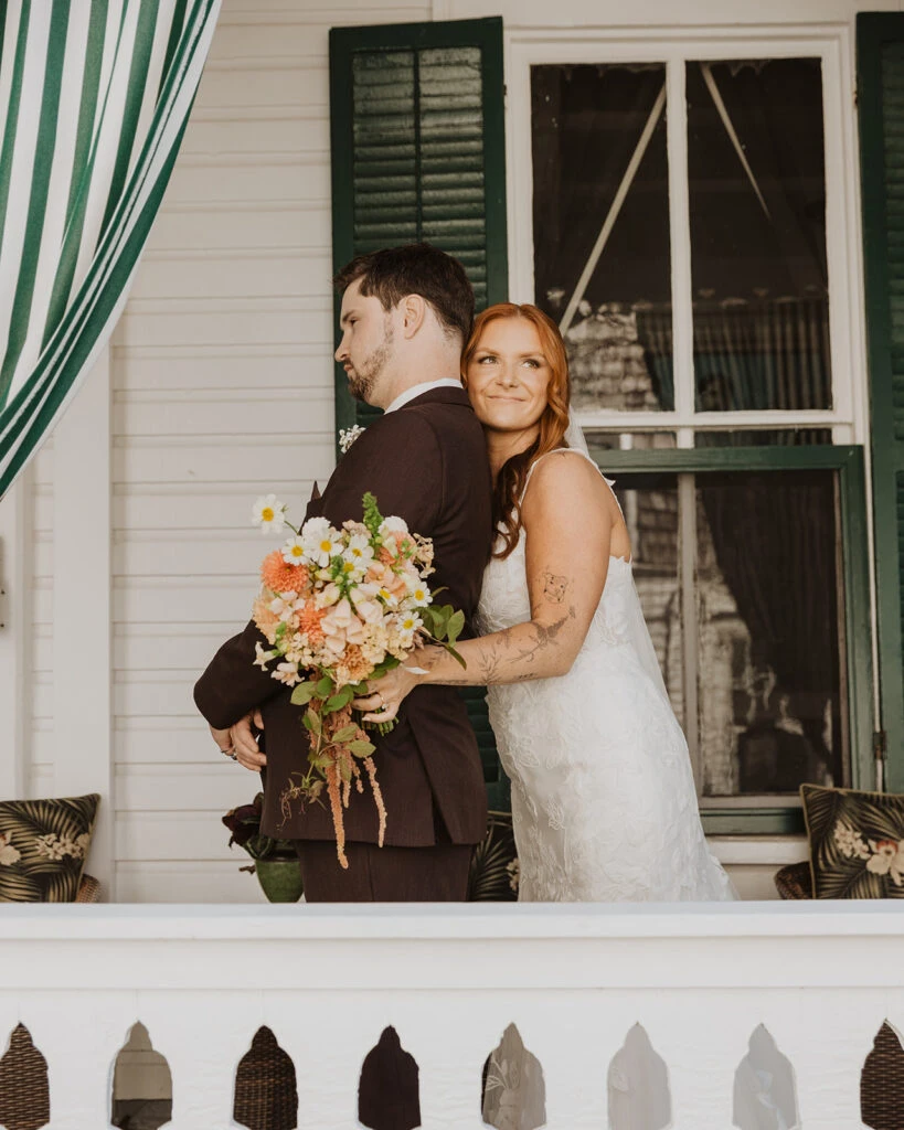 Real bride Mackenzie posing with her husband during her first look
