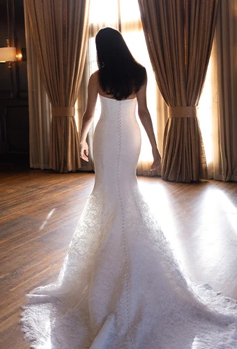 Bride wearing fit-and-flare strapless wedding dress with allover lace