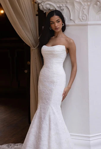 Bride wearing fit-and-flare strapless wedding dress with allover lace