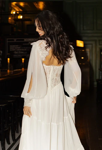 Bride wearing a line wedding gown with lace bodice and long blouson sleeves
