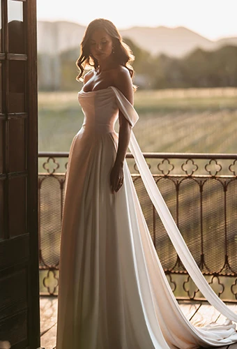 Bride wearing simple a line wedding dress with scoop neckline and off the shoulder straps
