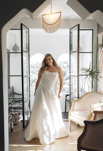 Plus size bride wearing satin strapless a-line wedding gown with floral details and cutout train, Stella York SY8279+