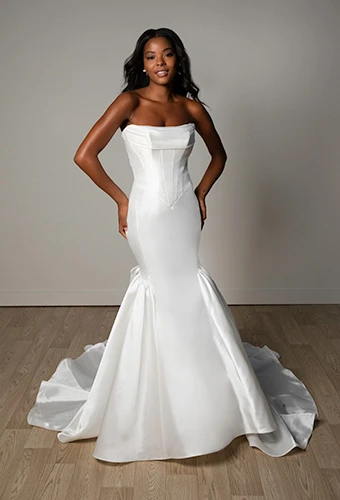Bride wearing strapless mermaid gown with corset bodice and cascading bows, Stella York SY8298