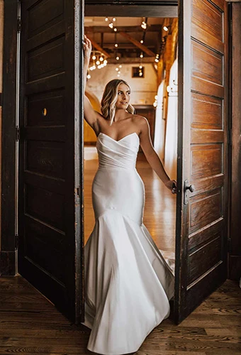 Bride wearing strapless mermaid dress with ruched fabric and pointed sweetheart neckline, Essense of Australia D3340