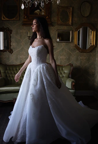 Bride wearing strapless ballgown wedding dress with allover lace and basque waist