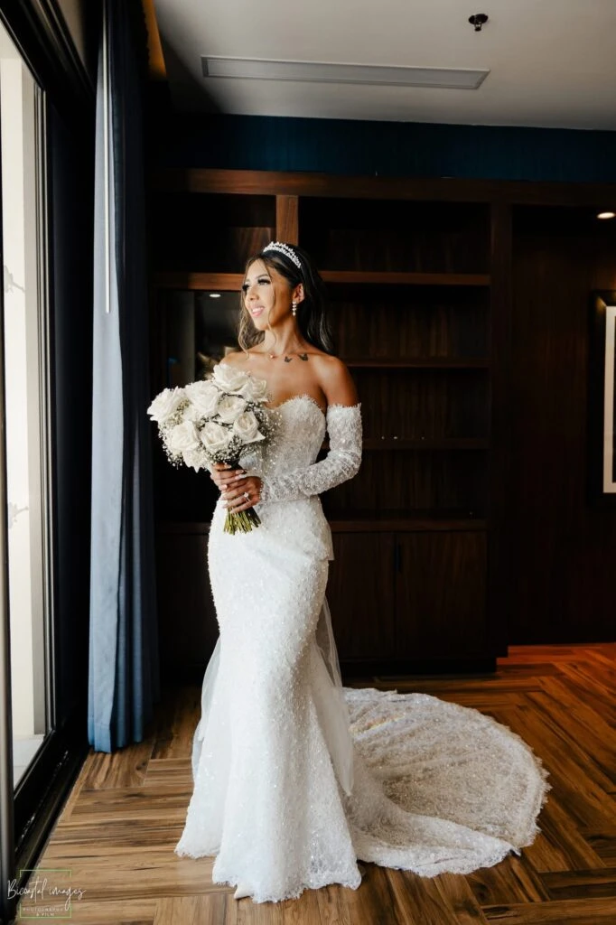 Real bride Sandra posing in her wedding gown with a flower bouquet
