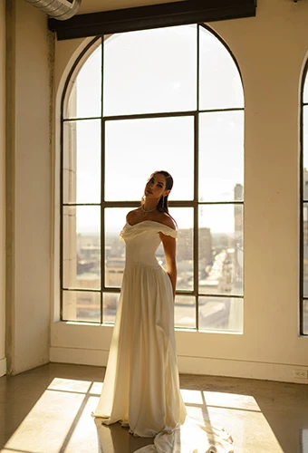 Bride wearing boho off-shoulder wedding gown with draped elements and basque waist, All Who Wander cosete