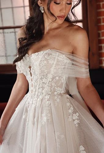 Close up of bride wearing wedding dress with floral corset bodice and tulle arm wraps, Essense of Australia D4286