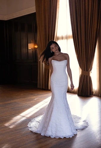 Bride posing in allover lace fit-and-flare wedding dress with soft scoop neckline, Essense of Australia D4522