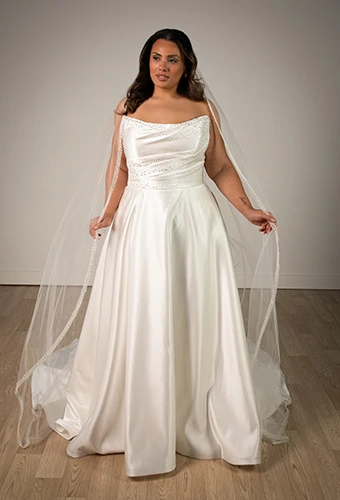 Plus size bride wearing minimalist strapless wedding dress with pearl detailing, Stella York SY8318+