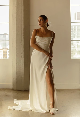 Bride wearing minimalist A-line wedding gown with thin straps and draped cowl neckline, All Who Wander rianna