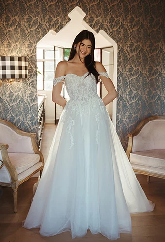 Bride wearing A-line wedding gown with detachable off-shoulder straps and lace tulle, Stella York sy8345