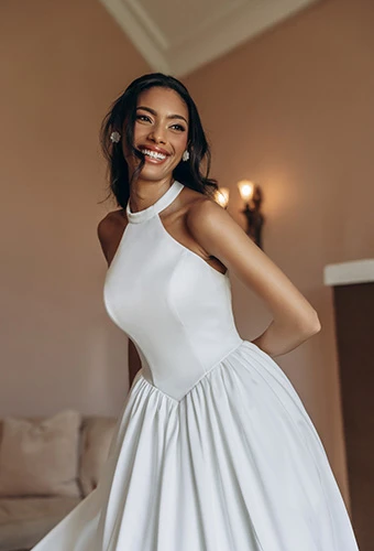 Bride laughs wearing satin A-line wedding dress with halter neckline, Stella York SY8273