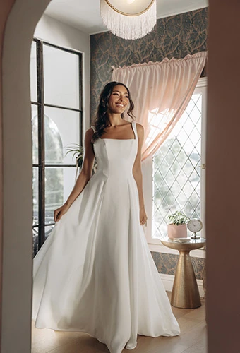 Bride wearing simple A-line wedding dress with square neckline and wide straps, Stella York SY8257