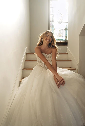 Bride smiles in sparkle tulle ballgown with sheer floral bodice, Stella York SY8301