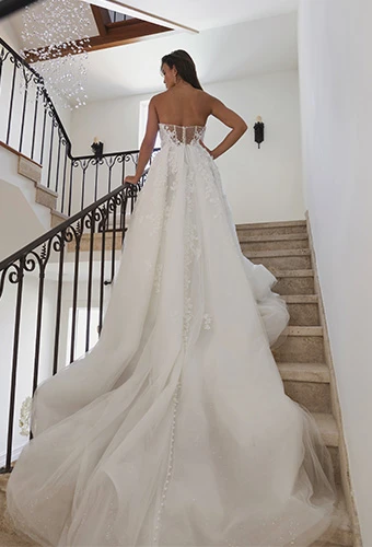 Bride wearing strapless wedding gown with floral lace details