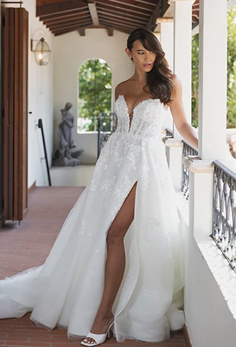 Bride wearing strapless wedding gown with floral lace details and high leg slit