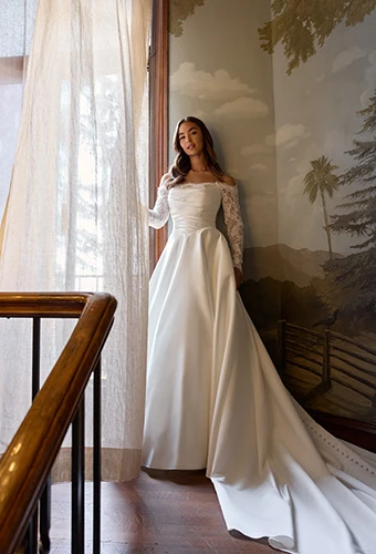 Bride wearing silk A-line wedding dress with ruched bodice and off-shoulder lace long sleeves, Essense of Australia D4457