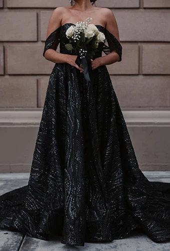 Close up of bride wearing sequin black A-line wedding dress holding white bouquet, Essense of Australia D3648BLK