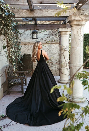Bride wearing black A-line wedding dress with full silk train and deep V open back, Stella York SY7755BLK